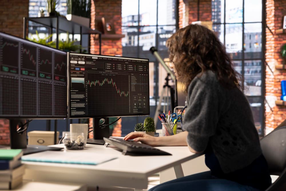Trader trabajando en un escritorio con varias pantallas